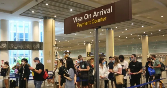 Travelers queuing at the Visa on Arrival (VOA) counter at Bali's airport.
